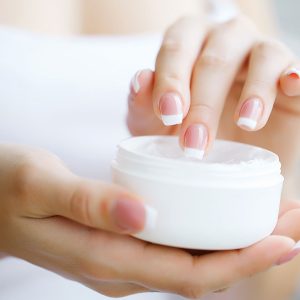 rimer plano de manos femeninas sosteniendo un tubo de crema